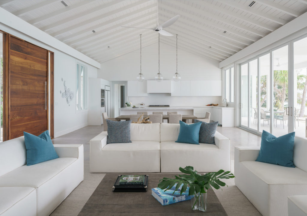 Elements of the design palette, relate to the amazing shades of blue in the ocean that is visible from the Great Room.  Inspired by Bahamian architecture, but with a modern twist, this tropical house incorporates Bahamian shutters, porches, breezeways, native keystone, and volume ceilings with wood cladding –elements with deep roots in Bahamian vernacular. The modern take on island architecture is embodied in the openness of the Great Room, the immediacy of the connection to the dramatic reflecting pool outdoors, and the simple concrete decks perched above the rocks and beach below. Sliding doors in the main space retract to allow for 20 feet of gorgeous, uninterrupted ocean views.